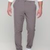 Man wearing taupe chinos with a white button-down shirt and white sneakers, standing straight.