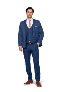 IMG_4744 - Noble Man in a blue three-piece suit with a tan tie, white shirt, and brown shoes posing against a white background.