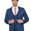 Man in a blue three-piece suit adjusting his jacket, white shirt, and peach tie against a white background.