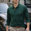Man in a dark green polo shirt and tan chinos wearing sunglasses, standing beside a car on a city street; looks stylish and confident. (Code: ΚΩΔΙΚΟΣ A70 SS/2026)
