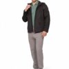Full-body portrait of a man modeling a black zip-up jacket over a green polo, gray pants and white sneakers against a white background.