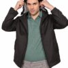 Man wearing a black jacket and green polo shirt pulls the hood up, against a white background.