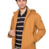 Man wearing a tan zippered jacket over a navy striped polo, standing against a white background.