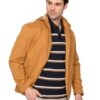 Man modeling a tan lightweight jacket over a navy striped polo and beige pants, looking to the side.