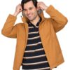 Smiling man in a mustard jacket adjusts the hood, wearing a navy striped polo shirt and beige pants.