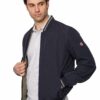 Man wearing a navy bomber jacket over a light gray polo, looking to his left with hand at the jacket. Or alternative: A man in a navy jacket peels open the front, gazing to the side.