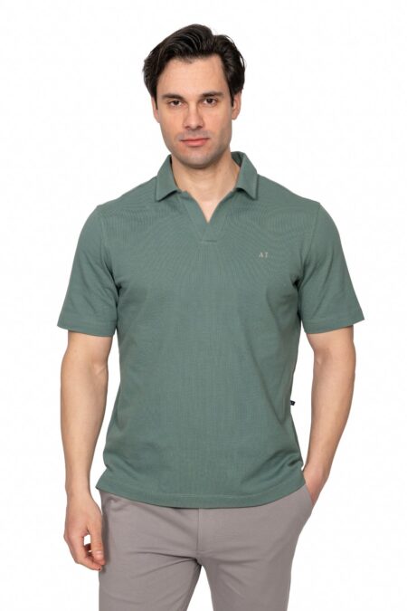 Male model wearing a sage green polo shirt and light gray pants, posing against a white studio background.