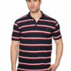 Man wearing a navy polo with red and white horizontal stripes, standing against a white background, with hands in pockets (casual model shot).