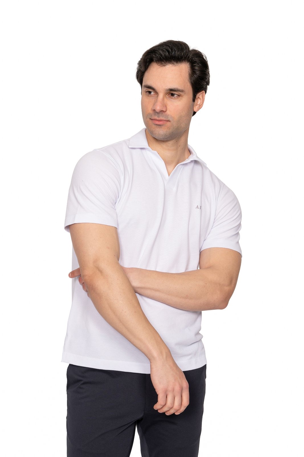 IMG_4934jpg - Noble Man wearing a white polo shirt and dark pants, arms crossed, looking to his left against a plain white backdrop.