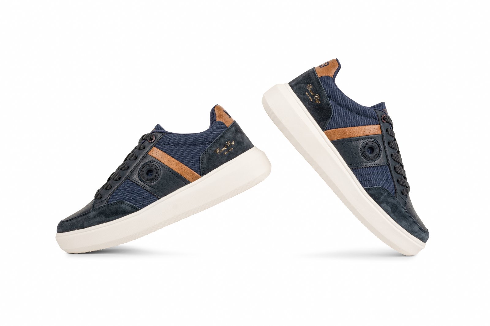 IMG_4935jpg - Noble Pair of navy blue sneakers with brown suede detailing and white midsoles, shown floating on a white background with laces tied.