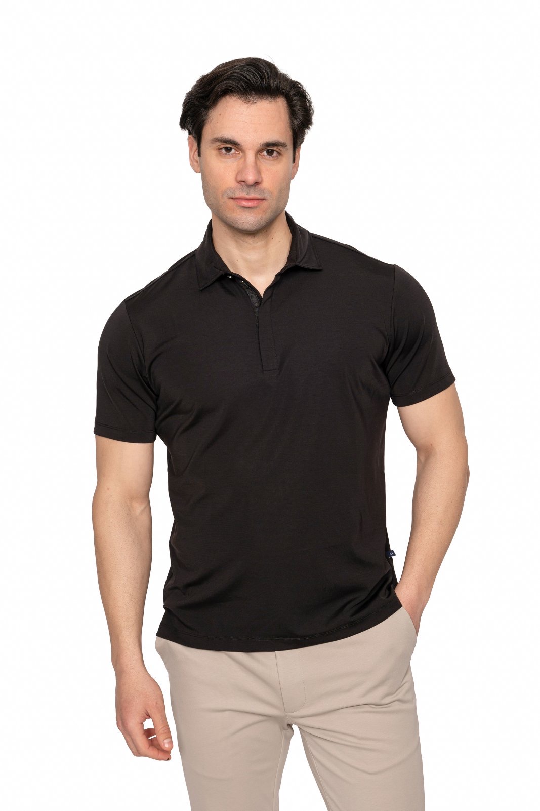 IMG_4956jpg - Noble Man wearing a black polo shirt and beige pants, standing against a white studio background.
