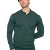 Man wearing a dark green long-sleeve henley shirt and beige pants, standing against a white background, looking at the camera.