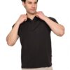 Man in a black polo shirt adjusts his collar while looking to the side against a white background