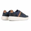 Navy blue sneakers with tan suede accents and a thick white sole, shown from the rear side.