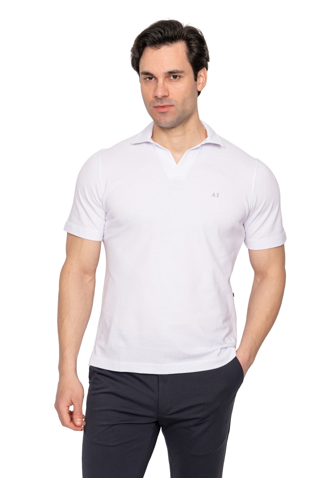 IMG_5056jpg - Noble Man wearing a white polo shirt and dark navy pants poses with hands at the sides against a white background, looking slightly to the left.