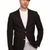 Man in a dark brown blazer over a white crew-neck shirt and light gray pants, posing with one hand in his pocket against a white background.