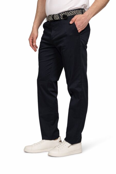 Man wearing dark navy chinos with a patterned belt and white sneakers; side pocket hand in pocket pose.
