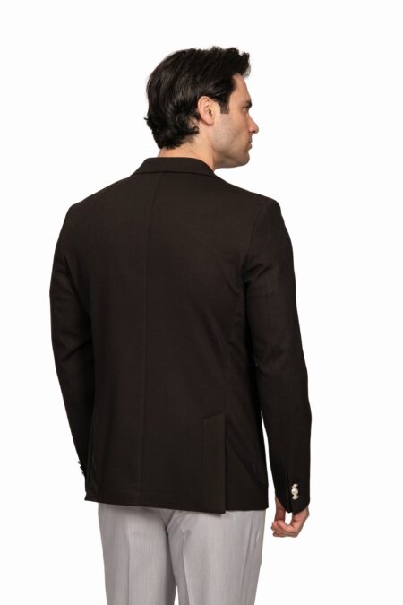 Back view of a man wearing a dark brown blazer and light gray pants.