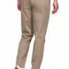Back view of a man wearing beige chinos with a braided belt and white sneakers.