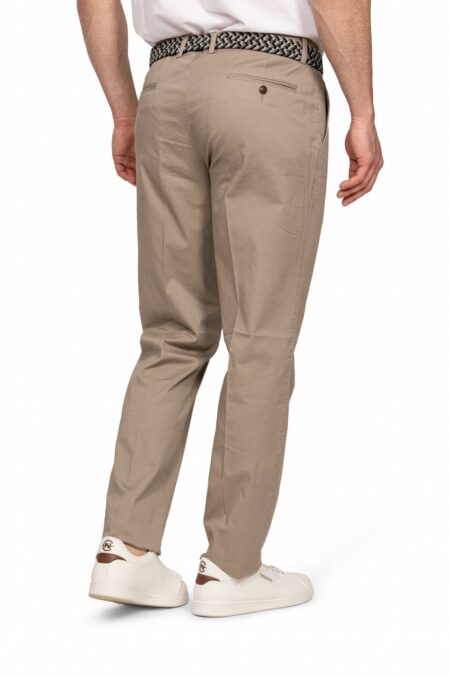 Back view of a man wearing beige chinos with a braided belt and white sneakers.