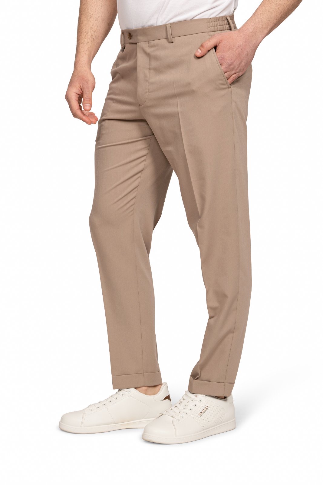 IMG_5209-6jpg - Noble Man wearing beige chinos with white sneakers, standing with one hand in his pocket.