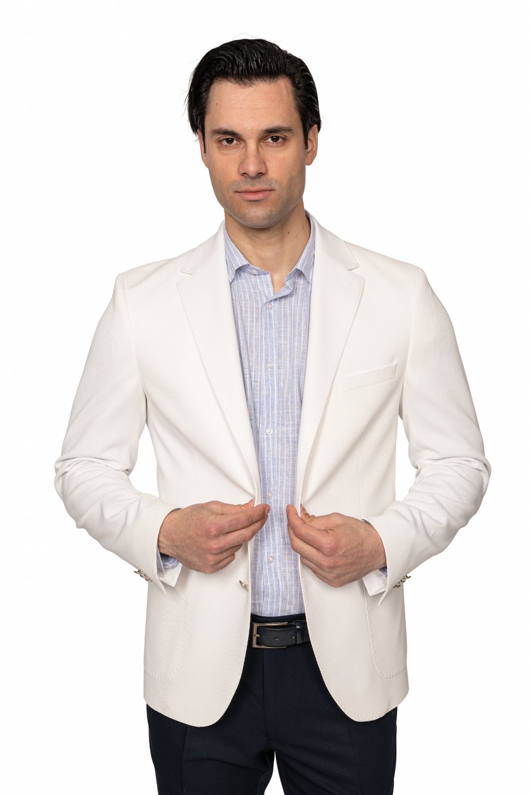 IMG_5213jpg - Noble Man in a white blazer and light striped shirt adjusts his jacket in a studio portrait.