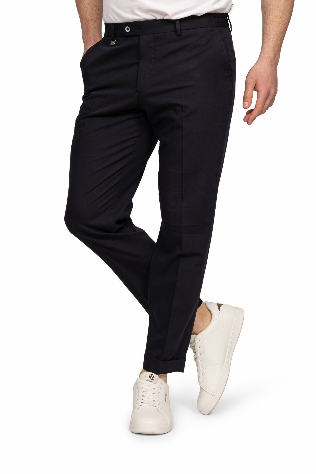 IMG_5217jpg - Noble Man wearing dark chinos and white sneakers, standing with one leg crossed in front.